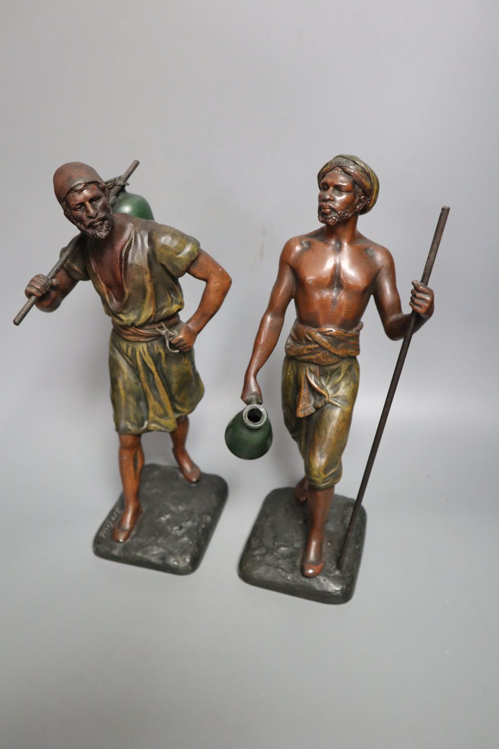 A pair of late 19th century painted bronze labourer figures after Debut, 12in., and a bronze figure of a playful girl, on marble plinth